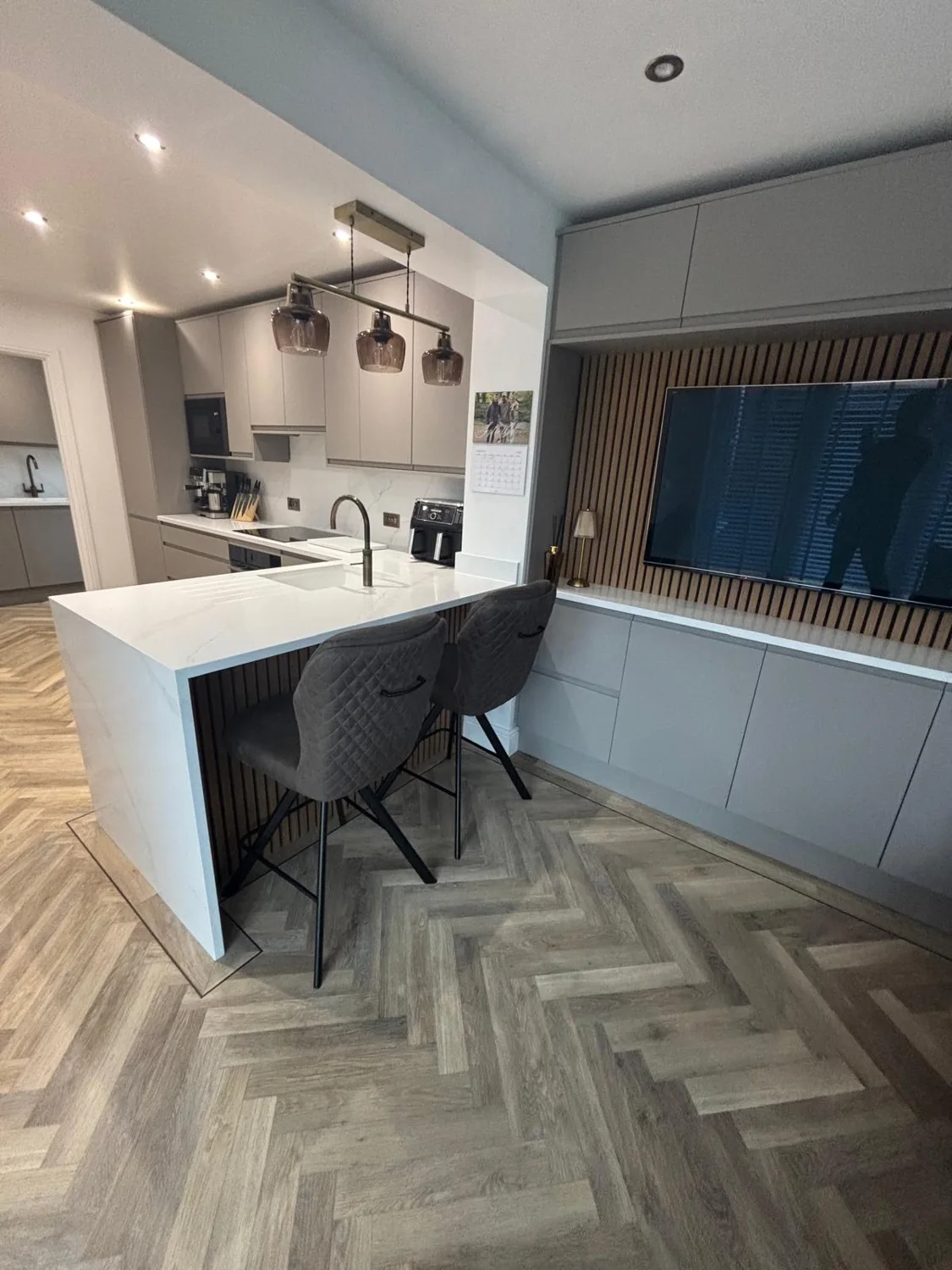 Modern kitchen with breakfast bar and herringbone flooring